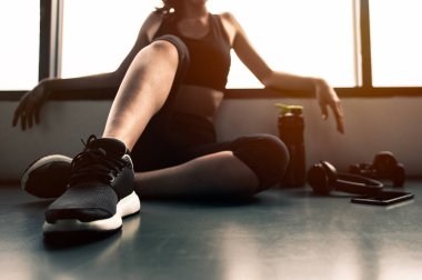 Eğitimden sonra dinleniyorum. Spor salonunda otururken gözlerini kaçıran güzel bir genç kadın. Spor yapmaya ara veren genç bir bayan.