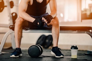 Vücut geliştirici, spor salonundaki halter ağırlıklarıyla çalışıyor. Halterle egzersiz yapıyor. Fitness kaslı vücut 