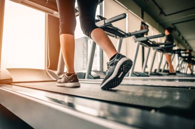 Ayakkabıya yaklaş, koşu bandında koşan bir kadın. Egzersiz konsepti. Fitness ve sağlıklı yaşam tarzı. 