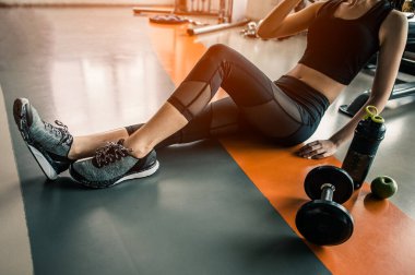 Spor salonunda egzersiz yapan genç bir kadın.