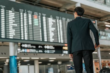 Zaman çizelgesinde akıllı telefon kullanan genç işadamı. Uçuş tahtası.