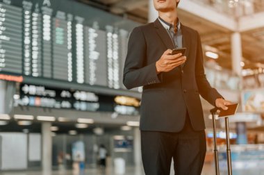 Zaman çizelgesinde akıllı telefon kullanan genç işadamı. Uçuş tahtası.