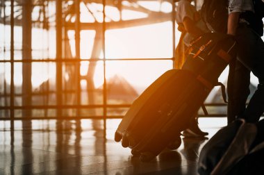 Havaalanında bavulu olan siluet aile yürüyor. bagaj havaalanı terminalinde yürüyor..