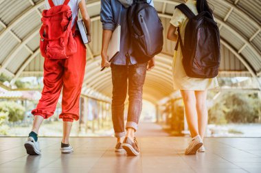 Öğrenciler tatilde üniversite salonunda yürüyorlar.