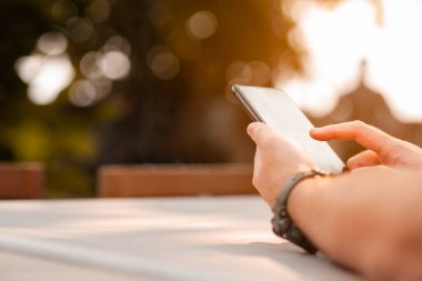 Cep telefonu kullanan bir adama yaklaşın. Yazın açık havada cep telefonu kullanan bir adam..