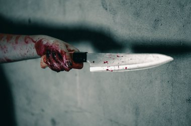 Kandaki zombi kız elinde bıçakla oturuyor. Kana bulanmış, dargınlık işkencesi görüyor ve terk edilmiş binada yardım istiyor. Cadılar Bayramı cinayet kavramı.