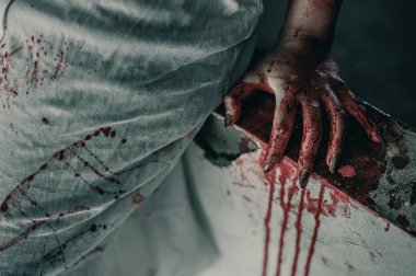 Kanlı elleri olan bir kadının korku sahnesi dargınlıkla oturuyor ve yardım istiyor, terkedilmiş binada, cadılar bayramı cinayet kavramında..