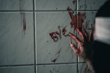 Korkunç kadın elinde kanla yardım isteyen bir mesaj yazmış. Cadılar Bayramı cinayet kavramı..