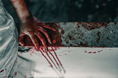 Kanlı elleri olan bir kadının korku sahnesi dargınlıkla oturuyor ve yardım istiyor, terkedilmiş binada, cadılar bayramı cinayet kavramında..