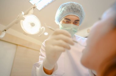 Diş hekimi, diş sağlığı ve gülümseme için klinikteki hastaları muayene ediyor..