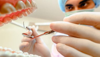 Dişçiler klinikteki diş modellerini etkili bir tedavi için inceliyor ve hastanın diş sağlığı ve parlak gülümsemelerini iyileştiriyor