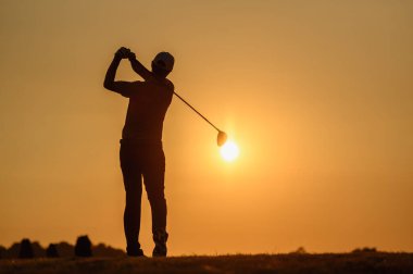 Yaşam tarzı, golf, aktivite, açık hava, spor, golfçü konsepti Bir adam yazın gün batımında golf sahasında golf oynuyor. Spor yaşam tarzı kavramı.