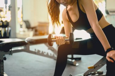 Spor, spor, spor, yaşam tarzı ve sağlıklı konsept. Kadınlar gün batımında sağlık için spor salonunda halterlerle egzersiz yaparlar..