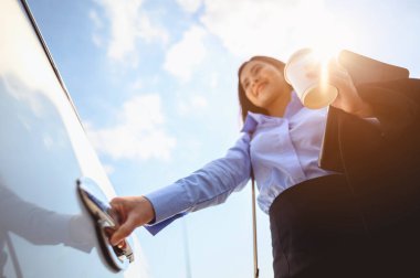 İş kadını, iş, iş, araba, çoklu görev, teknoloji konsepti. Yakın plan, iş kadını kahve fincanı ve dizüstü bilgisayarla arabanın kapısını açıyor..