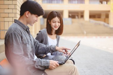 Eğitim, Öğrenme, Öğrenci, Kampüs, Üniversite, Yaşam Tarzı Konsepti. İki öğrenci merdivenlerde oturmuş eğitim için kitap okuyorlar. Üniversitede sınav hazırlığı için eğitim.