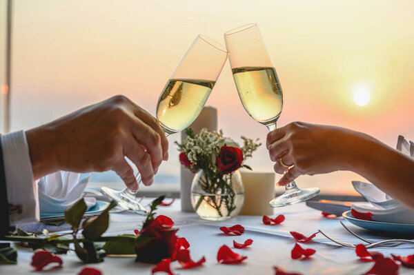 Couple enjoying of Cheers glass of wine  in a restaurant  at sunset. Valentine's, Couple, Honeymoon, Dinner, Wine, Romantic concept. 