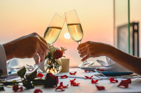 Couple enjoying of Cheers glass of wine  in a restaurant  at sunset. Valentine's, Couple, Honeymoon, Dinner, Wine, Romantic concept. 