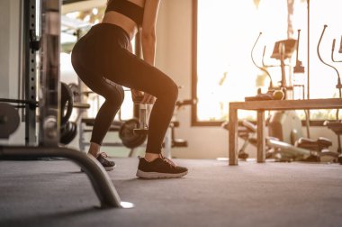 Dikiz aynasındaki kadınlar günbatımında sağlık için spor salonunda halterlerle egzersiz yapıyor. Spor, spor, spor, yaşam tarzı ve sağlıklı konsept. 