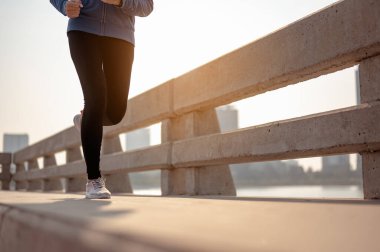 Ayakları yakın çekim genç kadın sabah antrenmanında şehirde koşuyor. Başkentte sağlıklı yaşayan bir şehir. Egzersiz, fitness, koşu, koşu, yaşam tarzı, sağlıklı konsept.