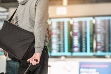 Gezginler yeni yerlere seyahat etmek için havaalanı uçuş çizelgesine bakıyorlar. Dikiz aynası. Uzayı kopyala Bavul, bilet, seyahat, havaalanı, yürüyüş, tatil konsepti