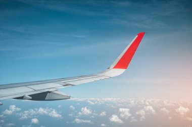 Uçağın kanatları turkuaz gökyüzünde ve turuncu ışık güneşinde uçuyor. Uçak, Seyahat, Kanat, Havalimanı, Gökyüzü, teknoloji kavramı.