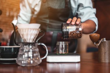 Yakın plan kahve makinesi, kahve barmeninin akşam güneşinde koyu beyaz bardakla kahve çıkarmasını sağlıyor. kahve, çıkartma, derin, makine, yapım, barista konsepti. 