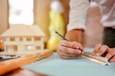 Gün batımında erkek mimar elleri ölçüp masanda model ev yapıyor. Mühendislik, Mühendislik, Mimarlık, Tasarım, Planlama, Meslek Konsepti.