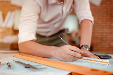 Gün batımında erkek mimar elleri ölçüp masanda model ev yapıyor. Mühendislik, Mühendislik, Mimarlık, Tasarım, Planlama, Meslek Konsepti.