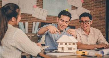 Erkek mimar elleri gün batımında masadaki takımlarıyla birlikte ölçüp model ev yapıyor. Mühendislik, Mühendislik, Mimarlık, Tasarım, Planlama, Meslek Konsepti