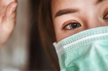 Pencerede maske takan kadın salgın durumunun yakında düzelmesini bekliyor. Coronavirus, covid-19, Home (WFH), Social Mesafe, Karantina, Enfeksiyon Önleme Konsepti.