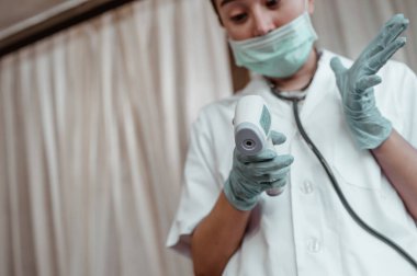 Doktor, Corona virüsü için hastanede vücut sıcaklığınızı kızılötesi alın termometresiyle ölçün. Coronavirus, covid-19, evden çalışma, sosyal uzaklık, karantina, enfeksiyon konseptini önleme.