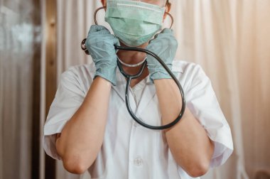 Doktor, Corona virüsü için hastanede stetoskop kullanarak hastanın vücut ısısını ölçün. Coronavirus, covid-19, evden çalışma, sosyal uzaklık, karantina, enfeksiyon konseptini önleme.