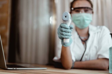 Doktor, Corona virüsü için hastanede kızıl ötesi alın termometresi kullanarak hastanın vücut ısısını ölçün. Coronavirus, covid-19, evden çalışma, sosyal uzaklık, karantina, enfeksiyon konseptini önleme.