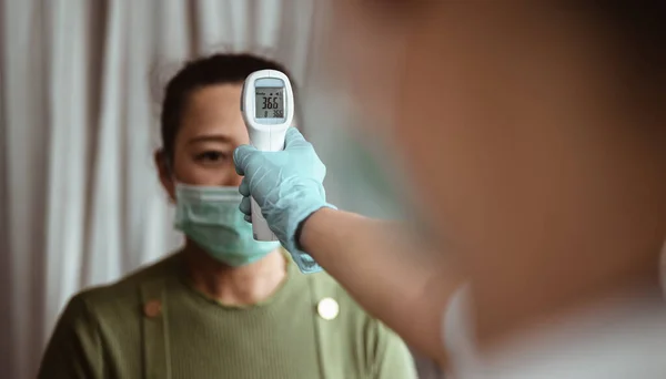 Médico Verifica Temperatura Corporal Del Paciente Usando Termómetro Infrarrojo Frente — Foto de Stock