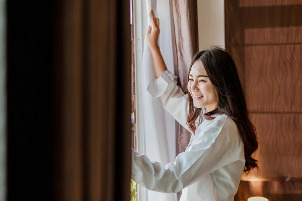 Young woman asia wake up refreshed in the morning and relax in the bedroom on holiday. Asian, asia, relax, alone, technology, lifestyle concept.