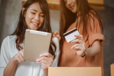 Genç Asyalı kadın internet pazarlaması müşteriler için satış ve teslimat siparişi veriyor. İş sahibi, KOBİ, taşımacılık, evden (WFH), serbest, başlangıç konsepti.