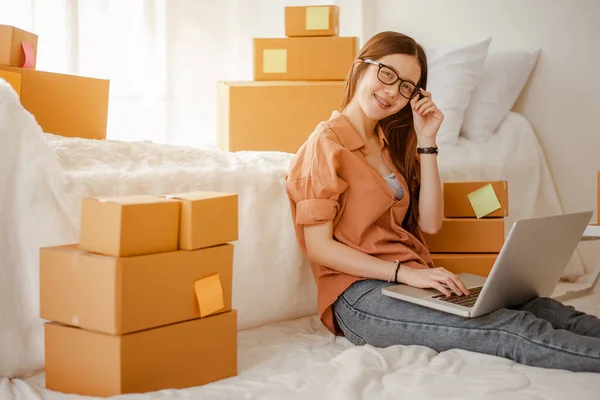 Young woman asian work from home talking with customers to sell products online and delivery for customer. Business owner, SME, shipping, work from home(WFH), freelance, Start up concept.