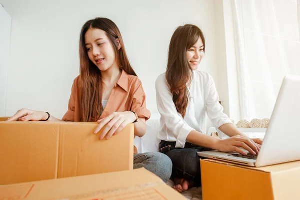 Young woman asian work from home online marketing packaging and delivery for customer at home. Business owner, SME, shipping, work from home(WFH), freelance, Start up concept.