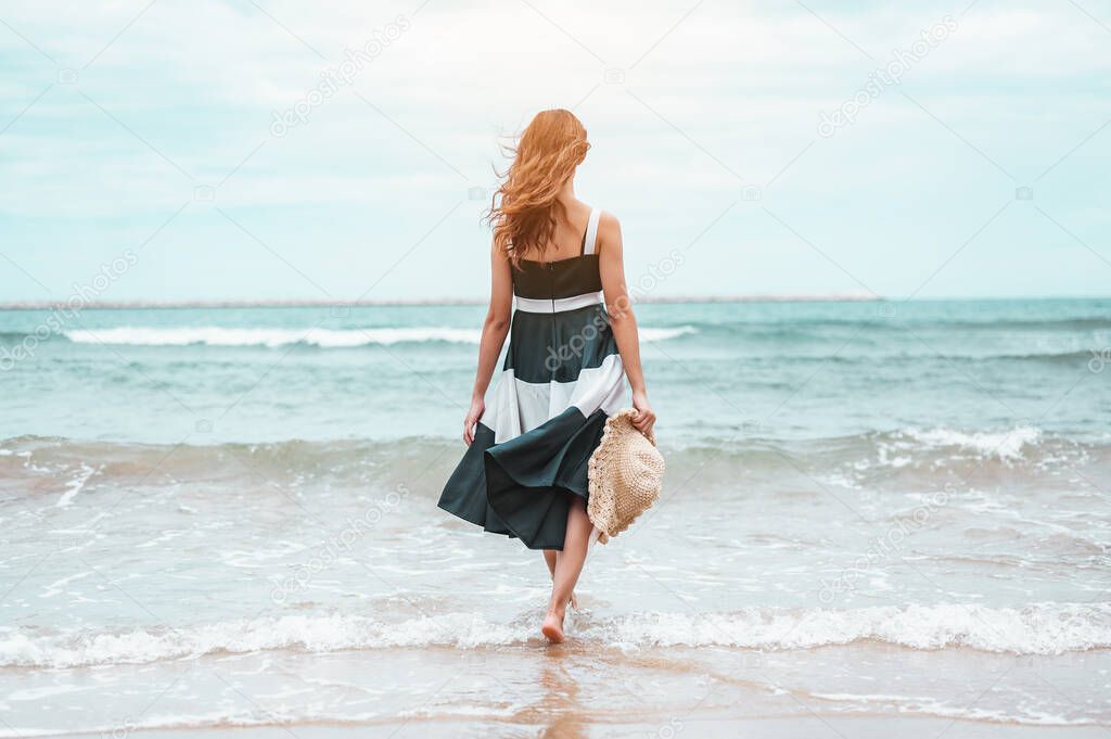 Happy asian women with holding hat walking barefoot to receive the wind and enjoy life on the beach vacation. beach, summer, liftstyle, positive mood, travel, relax concept.