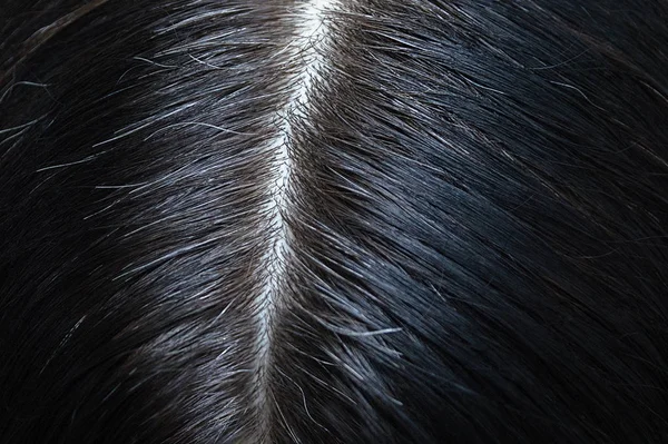 Siyah gri saçlı, yakın planda bir kadının kafası. Yukarıdan görüntüle.