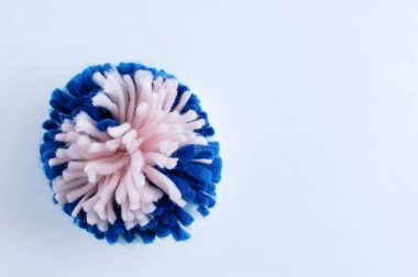 Beyaz arka planda mavi ve pembe renkli yün ponpon..