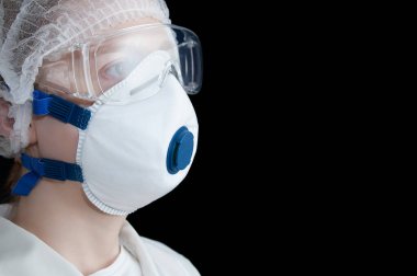 Koruyucu maskeli kadın doktor ve siyah arka planda gözlük..