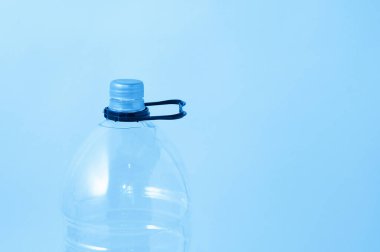 Kapağı kapalı şeffaf plastik şişe ve beyaz arka planda kalem tutacağı.