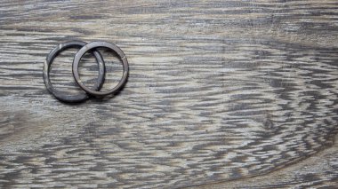 Ahşap arka planda el yapımı hindistan cevizi halkaları. Zanaatkar alyansları. Aşk ve birlik kavramı. Kopyalama alanı ile.