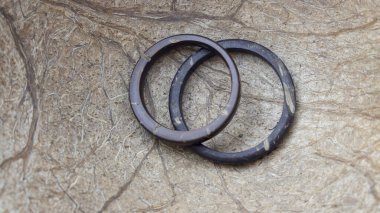 Onun ve onun el yapımı hindistan cevizi halkaları Hindistan cevizi arkaplanlı. Zanaatkar alyansları. Aşk ve birlik kavramı