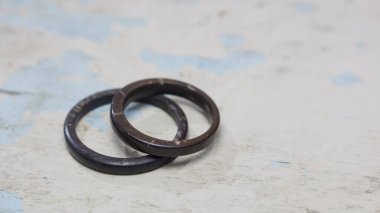 Pis ahşap arka planda el yapımı hindistan cevizi halkaları. Doğal ve zanaatkar alyanslar. Aşk ve birlik kavramı.