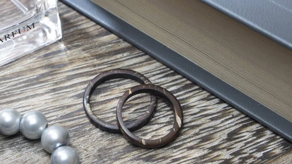 Artisan wedding ring bands, handmade from coconut in wooden table with props. Love and union concept.