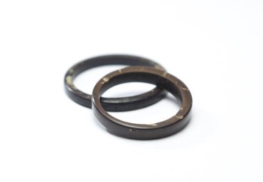 Beyaz arka planda eşsiz el yapımı hindistan cevizi halkaları. Zanaatkar alyansları aşkı ve birlikteliği simgeler..