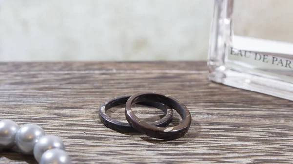 Unique artisan wedding rings, handmade from coconut in wooden table with props. Love and union concept, with copy space. Stock Image