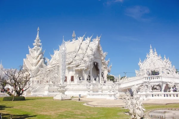 Bridge av cykeln av pånyttfödelse och utsmyckade byggandet av Vita templet i en ljus dag. Chiang Rai-provinsen, Thailand — Stockfoto